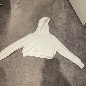 Kort vit hoodie  - Kroppad vit hoodie med luva, aldig använd. Köpt på zalado. 