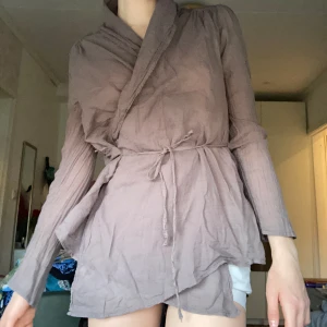 Blus  - Jättefin brun blus med snöre man knyter runt midjan och blommigt material mönster på ryggen🫶🏼