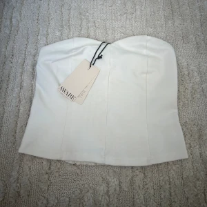 Vit tubtopp - Säljer denna supergulliga tuptoppen från Vero Moda då den inte kommit till användning💕 Skulle säga att den passar en S bättre.Den är helt ny med prislappen kvar. Kontakta mig vid frågor eller funderingar🥰 