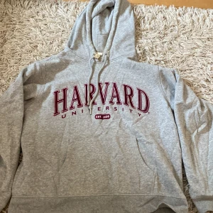 Grå Harvard hoodie - Grå hoodie med supermysigt material med en röd Harvard logga på framsidan. Inte använts mycket.  