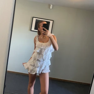 Kort klänning med volanger.  - Den är inte så kort som den ser ut! Den blir pyttelite längre där bak så den täcker allt som behöver täckas och är så fin till sommaren. Inga defekter. Storlek xs. 