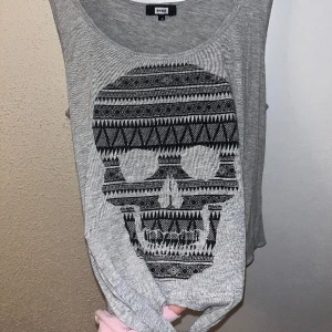 Grått linne med dödskalle🩶 - Fint linne från bikbok, inte blivit använt på väldigt länge och är fläckfritt som nyskick!🩶 Pris går att diskutera, går även att kombinera med andra plagg på min plick för ett stort nedsatt pris med billigare frakt!💞