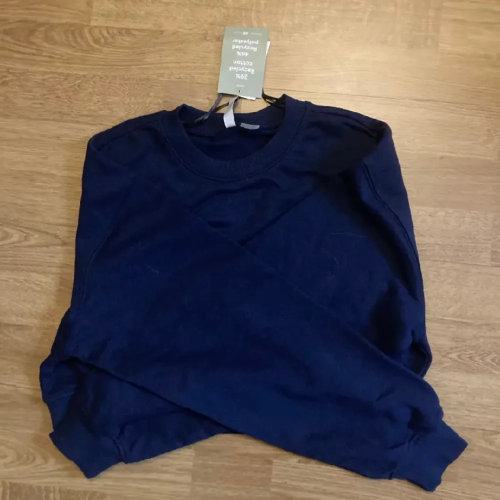 Säljer denna helt oanvända sweatshirten från H&M 🫶🏻 Croppad och når ungefär till naveln på mig som är 170 🙌. Hoodies.