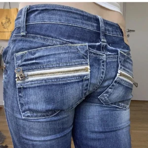 jätte fina lågmidjade flare jeans!! - jätte snygga jeans med snygga detaljer på fickorna!! midjemått är 75 och innerbenslängden 78 ish