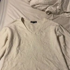 Vit stickad tröja - Vit stickad tröja med V ringning. Använd ett par gånger men är i bra skick.