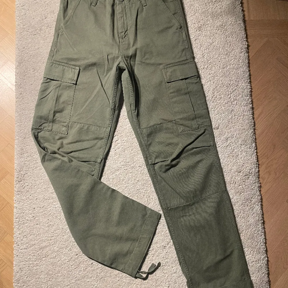 Gröna carhartt gröna byxor, sitter jätte bra med alla skor och går bra med flera olika stiler. Är i väldigt bra skick.  Fråga gärna för fler bilder. Jeans & Byxor.