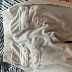 Juicy couture  - Vita juicy couture byxor i använt skick. Säljs till detta pris pågrund av skicket. Byxorna är inte håliga, sömmarna är fina däremot är byxorna missfärgade o där av priset. Finns matchande kofta även. 