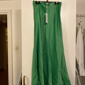 Grön, glansig  kjol. Ej använd 