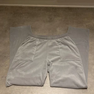 Mjukisbyxor i velour - Jättemysiga mjukisbyxor i velour, silver-ljusblå färg, tror de ska efterlikna Juicy Couture. Använda men i fint skick. Storlek S men upplevs som oversized. Snöret i midjan saknas!! Köparen står för frakt. 🩷
