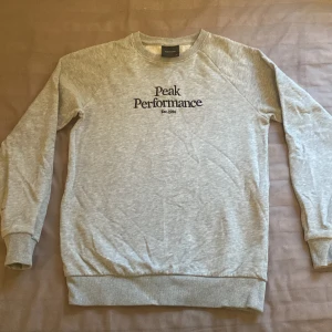 Sweatshirt Peak performance  - Välskött tröja som har en liten fläck på baksidan av höger ärm. Möjligt att den går bort med en mindre ansträng.  Djur- och rökfritt hem.