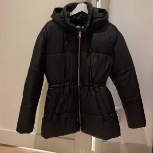Svart dunjacka - Svart dunjacka men snörning i midjan från vero moda, i storlek xs