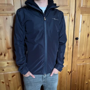 Windbreaker  - Storlek S men passar Xs. Skick 9/10 Mörkblå vindjacka som är perfekt nu till hösten i riktigt bra kvalite. Man kan lägga in luvan i kragen om van inte vill ha den. Priset kan diskuteras