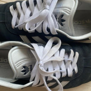 Adidas Gazelle gråa - Gråa adidas Gazelle i storlek 45.  Finns en liten defekt bak på vänstra skon (se bild 4) men absolut inget man märker av när man har på skorna.
