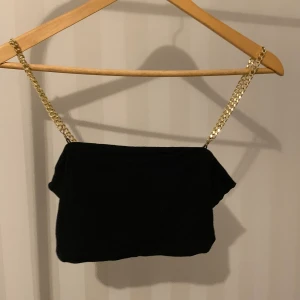 Svart topp med guldkedja, storlek xs - Sitter fint och har ett skönt material. Kjedjorna går att ta av ifall man inte vill ha dom eller när man ska tvätta toppen. Skriv vid mer information.