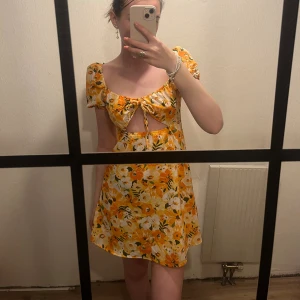 Orange klänning  - Orange klänning med blommor från H&M 
