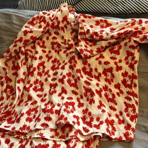 Sommarkläder  - Stl 36 blusen vit med röda blommor. Material viscos. Omlottkjol samma tyg stl38. Aldrig använt  