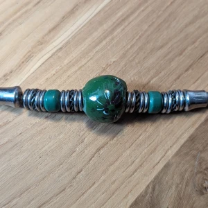 Halsband - Unikt halsband med blommig pärla på, ca 35 cm långt.