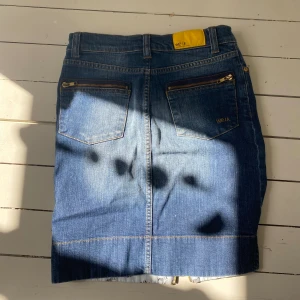 Jeanskjol  - Jeanskjol med dragkedjor. Längd är lite över knäna. Använd, mycket bra skick 
