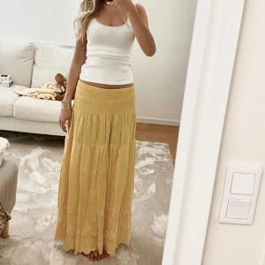 Lång kjol - Säljer denna gula maxi kjol med fina broderade detaljer längst ner. Helt ny med lapp som sitter kvar och köpt utomlands. Den är elastisk vid midjan så passar flera storlekar💕💕