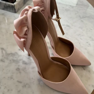 Rosa fest pumps med volang på hälen  - Jätte fina rosa klackar med volang på hälen . Använda 1 gång inne . 