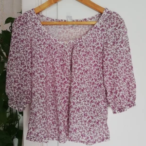 Blus lila blommor Strl 36 - Jättefin blus med trekvartsärm och knappar fram. Storlek 36. H&M. Axelbredd:36 cm Längd 52 cm. 100%bomull