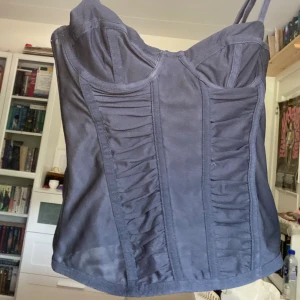 Svart sexig korset topp - Supercool korsettopp med delvis genomskinligt tyg. Passar XXS och XS med relativt liten kupa. Har bara provat den och säljer för att den var för liten på mig. Axelbanden och knäppningen är justerbar! Perfekt för utekvällar och klubb. Nypris 120kr