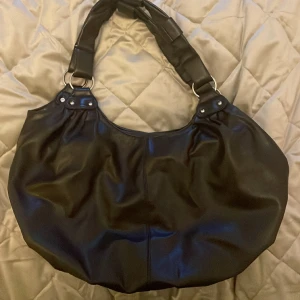 Rymlig brun väska  - Stor väska, mörkbrun. Tasig på tre ställen vid axelremmen men annars fint skick!