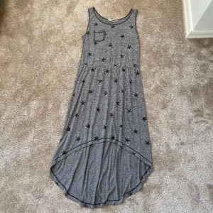 Klänning  - Grå klänning med svarta stjärnor på den har även en liten ficka på höger bröst, längre baktil än framtill🩶🖤
