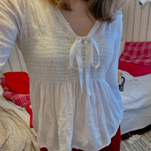 Vit blus - En vit blus med rosett man kan knyta 🤍 Köpt secondhand, med tecken på användning. Stretchig så passar S-M. 