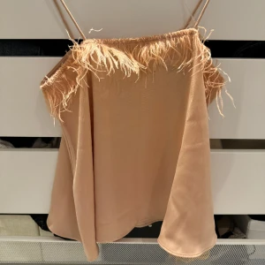 Söt rosa topp  - Jättegullig topp som är mer rosa i verkligheten med fjädrar på.  Får lite Barbie känsla av den. Aldrig använd. 