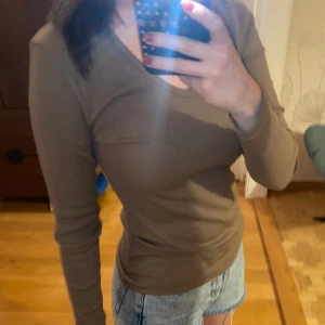 långärmad tröja - En helt ny oanvänd brun långärmad tröja. V ringning i halsen, ribbat material. Lappen sitter kvar. Storlek xs. Original pris 200kr