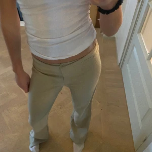 Beiga kostymbyxor - Beiga lågmidjade kostymbyxor, det står size 3 så jag antar att det är någon amerikansk storlek. Jag brukar ha 34 i byxor som referens