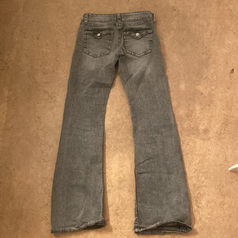 Säljer mina ljus gråa jeans från Ginatricot som har fickor med knappar på där bak och är låg midjade. Jeans & Byxor.