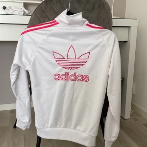 Tröja - Jätte snygg Adidas tröja som är i vit och Lite inslag av Rosa💓Lappen är av men skulle tippa på en xxs/xs och är super bekväm! Är använd några gånger men skulle säga att den är i väldigt bra skick💓 finns någon liten fläck! Säljer för den inte kommer till användning mer!