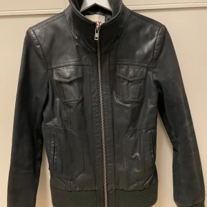 Skinnjacka - Skinnjacka med resår på insidan av kragen, runt midjan och muddar. Storlek M, men passar bra på S också.