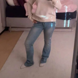 Ljusblå jeans  - Fina ljusblåa lågmidjade utsvängda jeans. Har slitningar längst ner vid fötterna bild 3. Midjemått är 36 rakt över och innerbenslängd är 76  