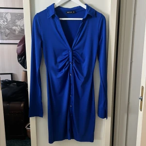 Marinblå långärmad klänning - Marinblå långärmad button down klänning från NLYONE i storlek S. Igensydd längst ned för att det var väldigt öppet. Stygnen syns ej när klänningen är på