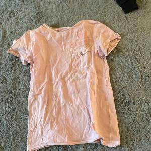 En rosa t-shirt som tyvärr är för liten för mig. Ficka på ena sidan