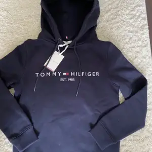 Oanvänd hoodie från Tommy Hilfiger! Marinblå färg och storlek xxs men passar som xs/s Nypris 1200kr Helt ny med tags 