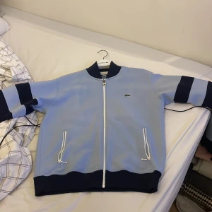 Lacoste tröja - Säljer min Lacoste Cardigan, den är i relaxed fit & säljs pga kommer inte till användning! Liten fläck på framsidan