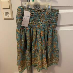 Somrig kjol köpt i Spanien. Den är onesize men skulle säga XS-M. Man kan välja att vika ner överdelen som på bild 3. Aldrig använd. 