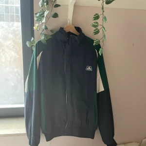 Holloway jacka tunn - Tunn sommar/vår/höst jacka Använd bara fåtal gånger, köpte secondhand för ca 450kr Dragkedjan är dessvärre lite sönder och är svår att stänga men det går, annars finns två knappar man kan stänga den med. Kom privat för mer info🫶🏼  