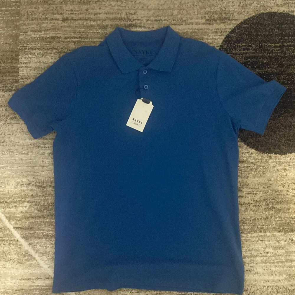 Fynda, Piké t-shirt för finare sommarväder redo att användas till någon som vill skina i blått. Det står L, men egentligen är det M eller S i storleken. Helt ny oanvänd. . T-shirts.