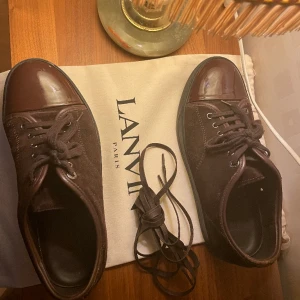 Bruna/ vinröda lanvins captoe  - Säljer mina lanvins uk 6 som passar 40-41. De är bruna med nyanser av vinröd. Skick 9/10 enbart använda ett par gånger har en jätte liten vit fläck på ena captoen inget som syns tydligt. Dustbagen och extra skosnören medkommer. Tar gärna emot frågor😀