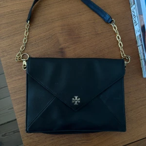 Tory Burch clutch - Tory burch clutch i svart med guldetaljer. Lädret är i fint skick men tyvärr är detaljerna lite slitna. 