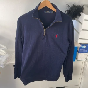 Marinblå Ralph Lauren Half-Zip - Tröjan är i storlek S och är i 8,5/10 skick. Detta är bara intressekoll för att se hur mycket tröjan går för. Nypris är även 1599 kronor.