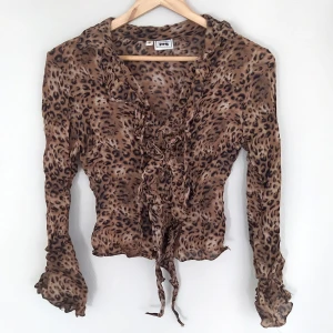 Leopardblus - Blus i fint skick förutom litet hål vid sömmen i nacken (se bild 3). Säkert lätt att sy igen och inte synligt. Men billigare pris pga detta såklart. Snörning fram och lite vidare i slutet av ärmarna. Pris diskuterbart ~