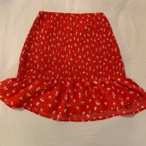 Nästan helt oanvänd medellång kjol med rött och vitt mönster med volang i storlek xxs men är väldigt så passar upptill en S/M💓