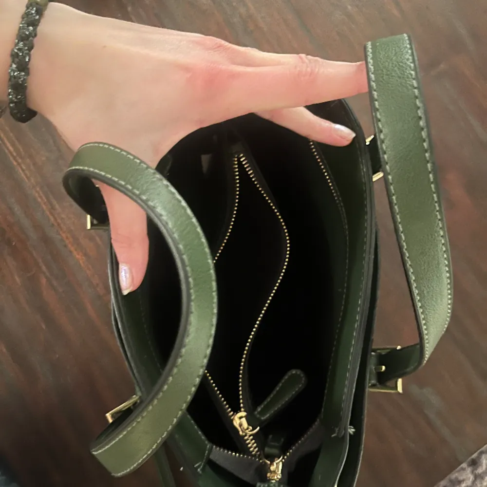 Olivgrön väska med både korta och långa band. Guld detaljer och massor med fack!. Väskor.