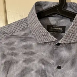 Snygg mönstrad skjorta från dressman i storlek M. Den är i bra skick. Mörkblå knappar. Stor i storleken. Egyptisk bomull. 